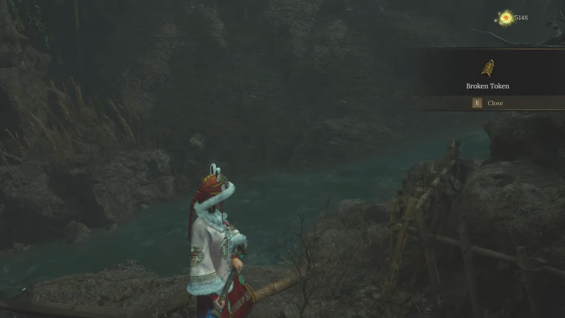 The Broken Token is located by the fence near the river