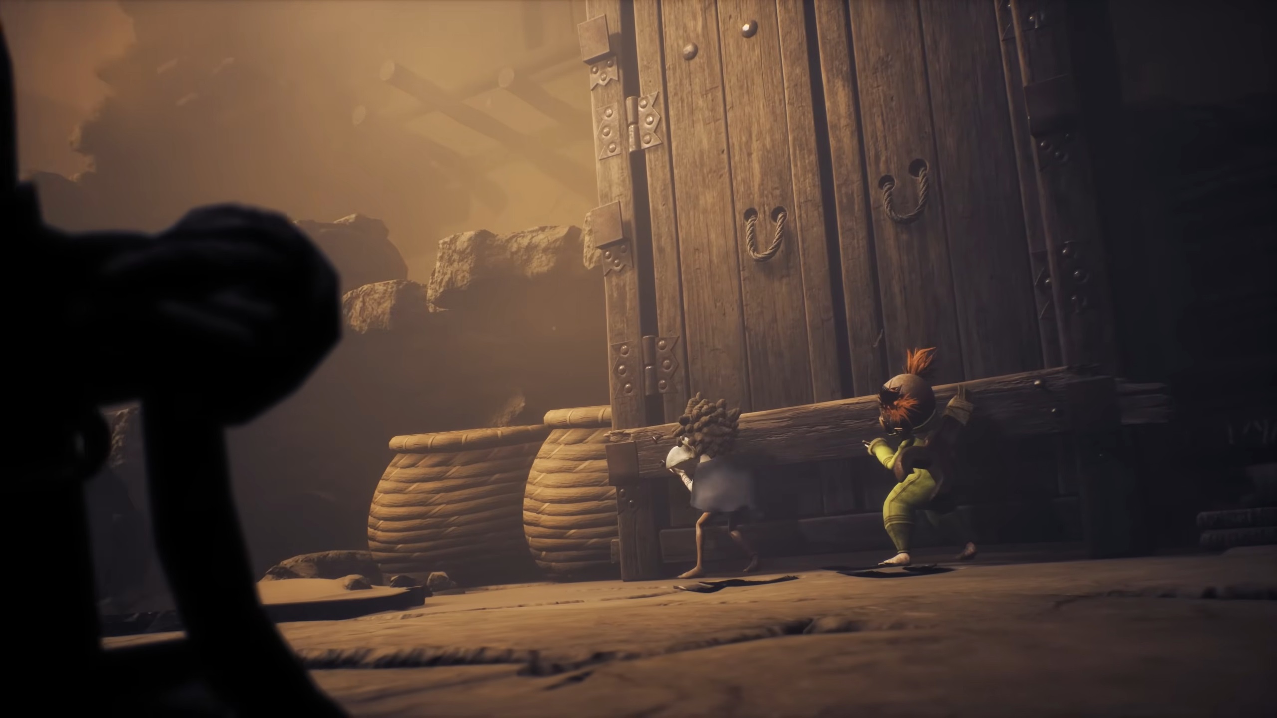 Picture describes Low and Alone trying to open a door in Little Nightmare 3